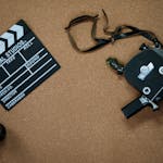 Vintage camera and clapboard on a cork board evoke a classic filmmaking vibe.